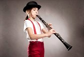 26199094-little-girl-playing-clarinet-on-a-gray-wall