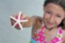 ist1_4723669_beautiful_girl_holding_starfish_at_the_beach.jpg